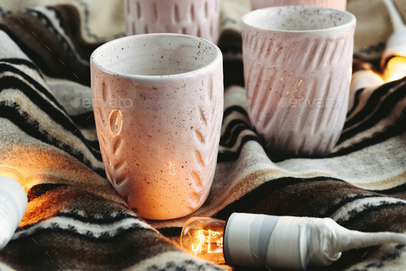 stylish creative ceramics cups and christmas garland lights, holiday celebration concept