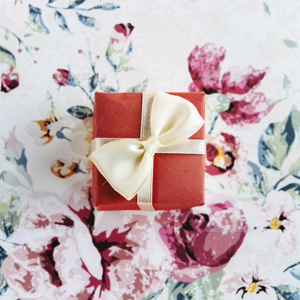 simple surprise little box with bow  on stylish flower paper, holiday celebration concept - Stock Photo - Images