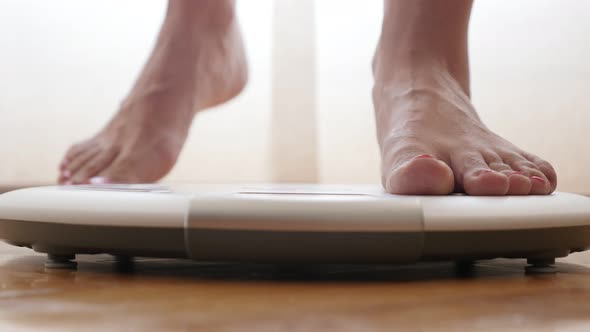 Woman feets stepping off personal weight measure device close-up 4K 2160p 30fps UltraHD footage - He alt