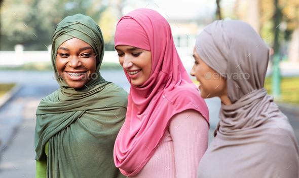 Three Cheerful Muslim Women In Hijab Walking And Talking Outdoors - Stock Photo - Images