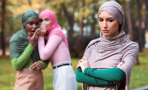 Bad Friends Talking About Unhappy Muslim Woman Standing Alone Outdoor