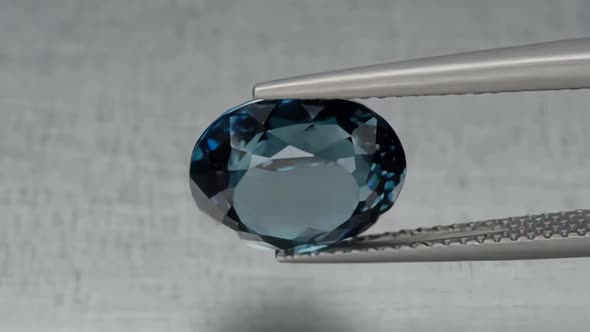 Natural London Blue Topaz Oval Cut in the Turning Tweezers