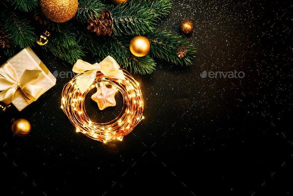 New Year black background with Christmas tree, gold garland and gift Stock Photo by ira_evva