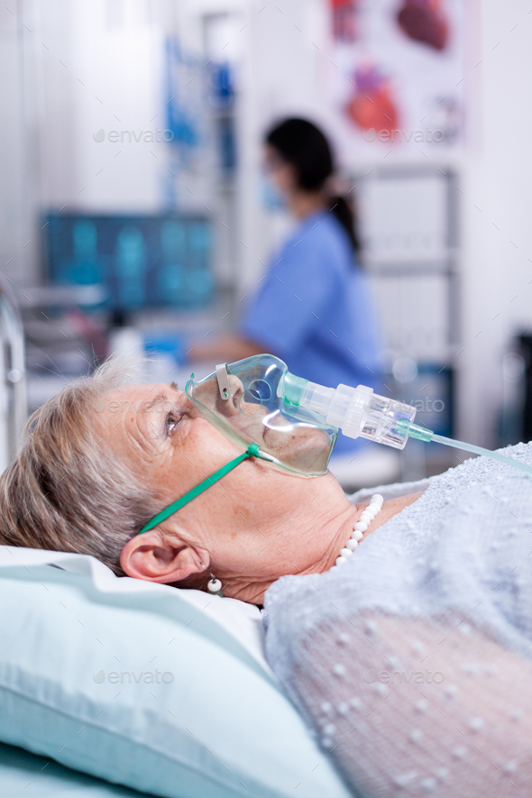 Oxygen mask helping old woman breath
