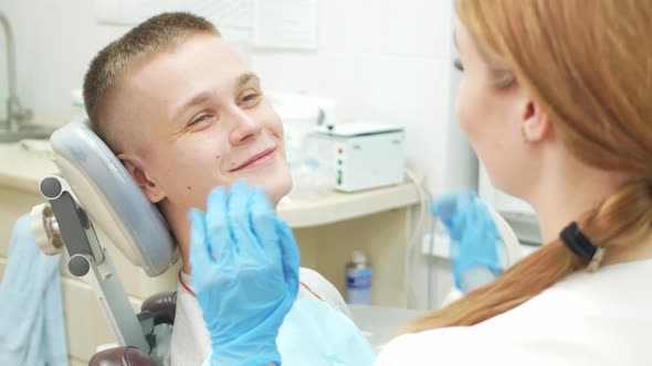 Caring Doctor Reassures Client Dentist in Clinic is Beautiful Woman