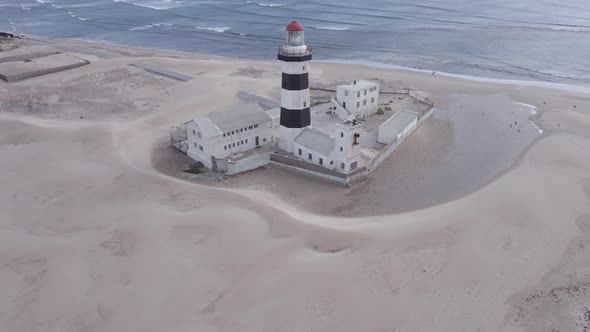 Drone Flying Over Lighthouse with Ocean in Horizon