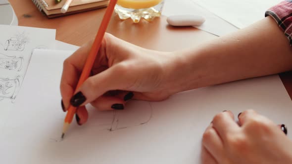 Woman Artist sketching on white paper, working from home office