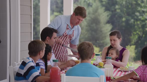 Group of people eating and enjoying a backyard barbeque