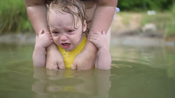 Little Funny Cute Blonde Girl Child Toddler in Yellow Bodysuit Crying Afraid of Learning Swim
