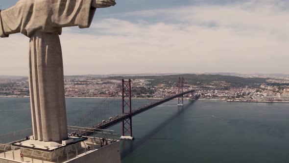 25 de Abril Bridge over Tagus River and the Sanctuary of Christ the King. Aerial pullback shot alt