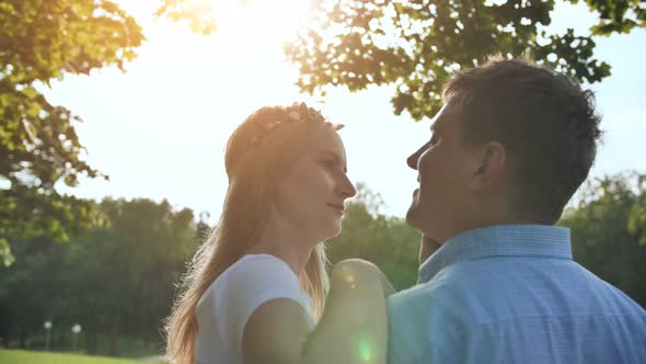 A Young Man and Woman are Hugging in a Park on a Summer Day alt