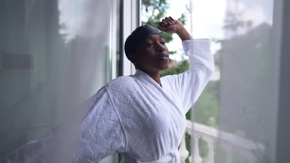 Medium Shot Happy African American Woman Stretching in Slow Motion Waking Up on Weekend Morning alt