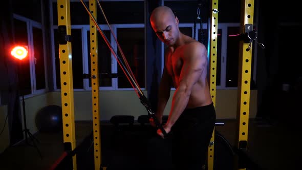Male Bodybuilder Training with Resistance Bands for Triceps in the Gym alt
