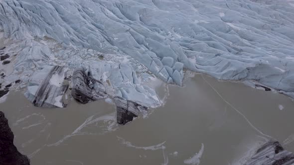 Aerial view of glacier and lake with iceberg floating on the water