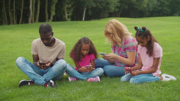 Phone Addicted Family Ignoring Each Other Outdoors alt