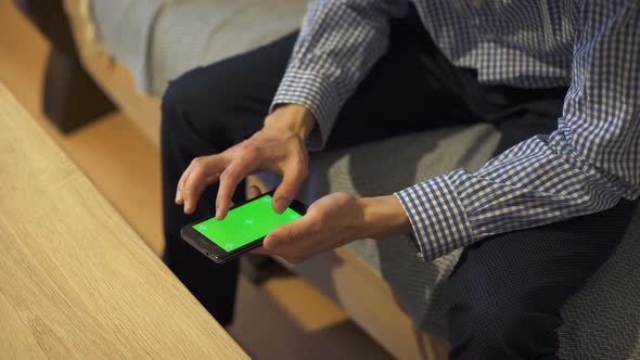 Man is Holding Smartphone with Green Screen in Home