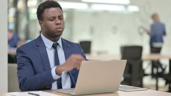 African Businessman Reacting to Loss While Using Laptop alt