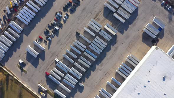 carrier company huge truck containers fleet in parking warehouse, orbital aerial alt