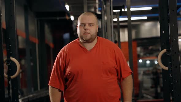 Overweight Man Lifting Dumbbells Looking at Camera Posing. Fat Male Working Out