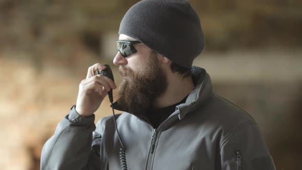 Serious Bodyguard Man Turn Left and Using Walkietalkie Security Guard or Military Man Patrolling alt