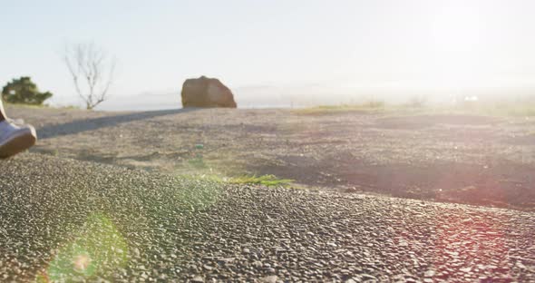 Low section of african american woman exercising outdoors running in country side during sunset alt