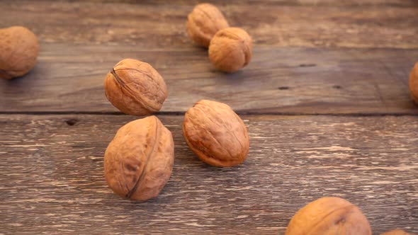 Walnuts are falling on the old wooden vintage board alt