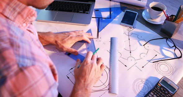 Male architect working on blueprint at his desk 4k alt