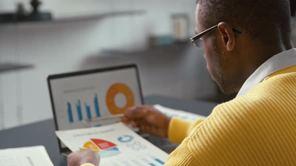 Young african man with laptop at work at home office. Working man with laptop alt