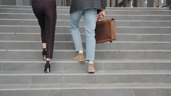 Full Length of Muslim Woman and Man Walking Together Near Modern Office Building alt