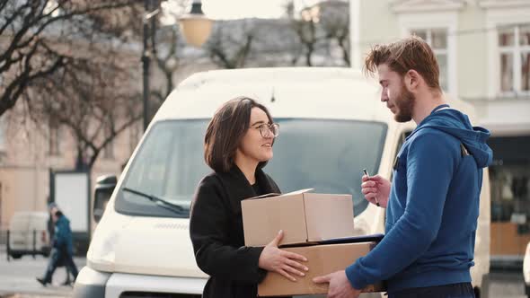 Delivery Man Giving Parcel To Happy Female Client Outdoor