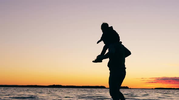 A Father Is Having Fun with His Kid at the Shore alt