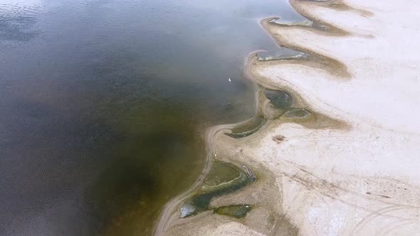 A small bays of the river of unusual shape. Sandy river coast, ripples on the water