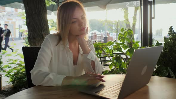 Beautiful Woman Runs on the Touchpad of a Laptop in a Cafe Makes a Search on the Internet Works