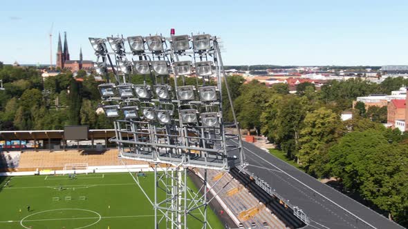 Drone flying near stadium floodlights with soccer field in background, Studenternas Uppsala in Swede alt