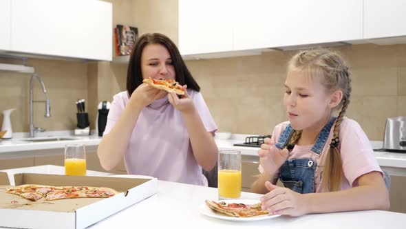 Happy Smiling Family of Two Eagerly Eat Delicious Pizza Little Girl Daughter with Sits with Her