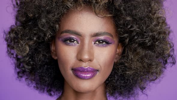 Portrait of Beautiful African American Female Model with Amazing Glowing Purple Fashion Makeup