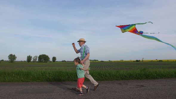Grandpa with Boy Running with Kite in Countryside alt