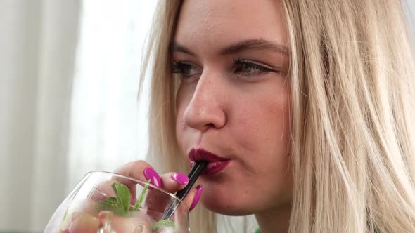 Blonde Woman Drinking a Cocktail alt