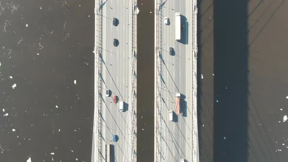 Stream of Cars Rides Through a Cable-stayed Bridge Across the River, Shooting From a Drone alt
