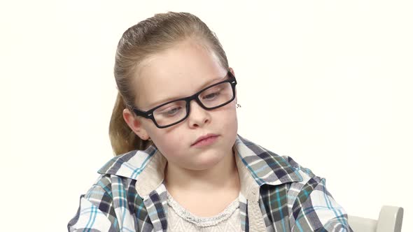 Little Girl Sits and Writes That His Notebook. White Background. Close Up alt
