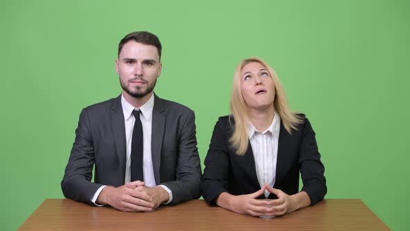 Young Businesswoman Making Funny Faces to Young Businessman