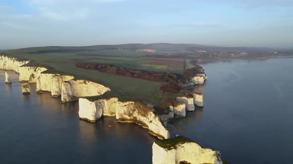 Old Harry Rocks cliffs and green English countryside, Dorset in England. Aerial forward alt