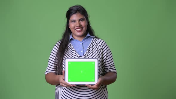 Young Overweight Beautiful Indian Businesswoman Against Green Background alt