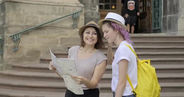 Mother and Teenage Daughter in Old Tourist City with Map alt