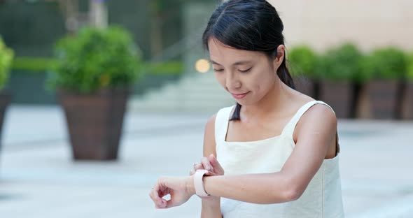 Woman use of smart watch at the street alt