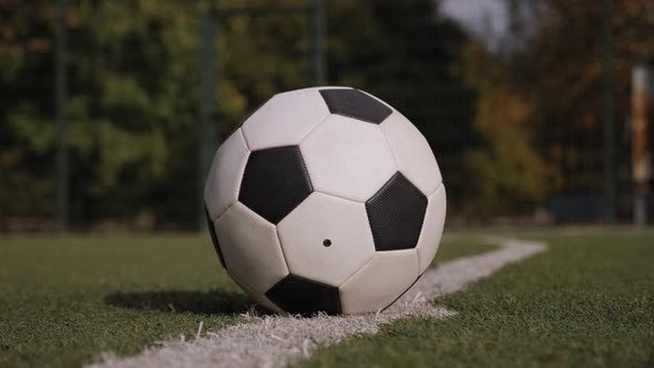 Close-up of Schoolboy Boy in Football Boots Hitting the Goal with a Soccer Ball alt