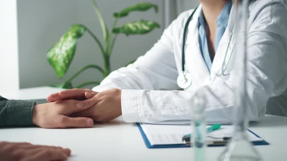 Doctor Pediatrician Holds The Patient By The Hand Calming Him. The Doctor Reassures The Patient alt