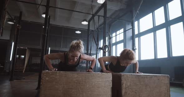 Slow Motion Two Young Beautiful Female Athletes Working Out Doing Pushups and Clapping Together in alt