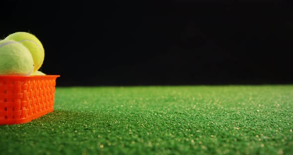 Tennis balls in red basket at studio 4k alt