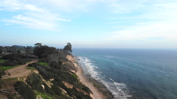Aerial drone shot over the beach cliffs of the Douglas Preserve in Santa Barbara, Californai with bl alt